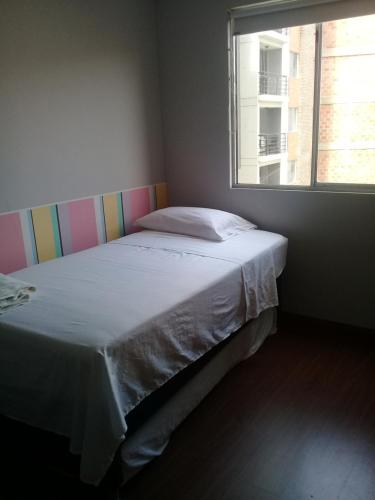 a bedroom with a large bed with a window at Apartamento En Sabaneta in Sabaneta