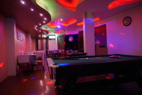 a pool table in a room with pink lighting at Hotel Park Residency, Kakkanad in Kakkanad