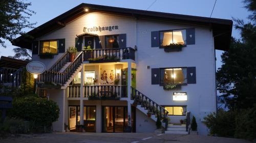 a large white building with stairs in front of it at Troldhaugen Lodge - Adults Only in Jindabyne