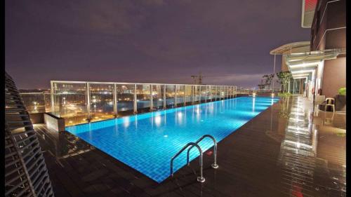 a large swimming pool on top of a building at night at Afiniti Muslim Medini Condo in Nusajaya