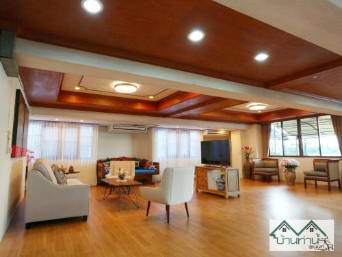 a large living room with wooden floors and furniture at Baanthanam Nont in Nonthaburi