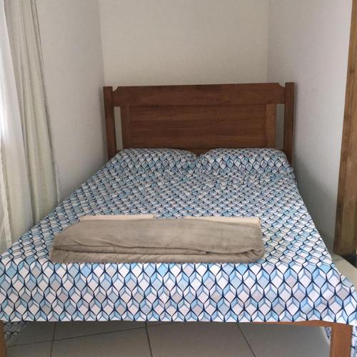 uma cama com uma cabeceira de madeira num quarto em Pousada Amazonas em Itabuna