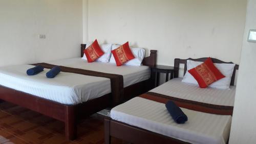 a room with two beds with red and white pillows at Bang Son Golden View in Baan Khai