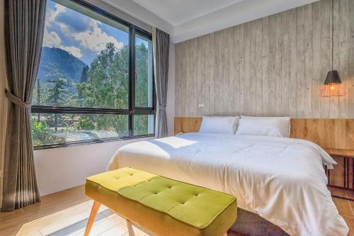 1 dormitorio con cama y ventana grande en Kapamumu b&b, en Yuchi