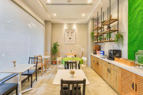 un restaurante con mesas y sillas y una pared verde en Kapamumu b&b, en Yuchi