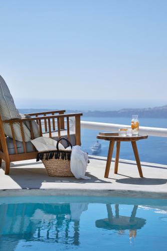 a table and bench next to a swimming pool at Senses Boutique Hotel in Imerovigli