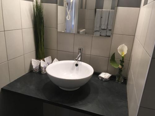 a bathroom with a white bowl sink on a counter at Hotel La Chaumiere in Saint-Gervais-les-Bains