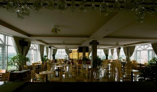 a large room with tables and chairs and windows at AEC Hotel Ban Me in Buon Ma Thuot