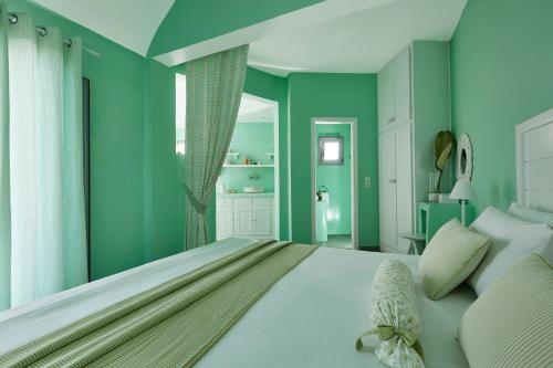 a bedroom with green walls and a large bed at Senses Boutique Hotel in Imerovigli