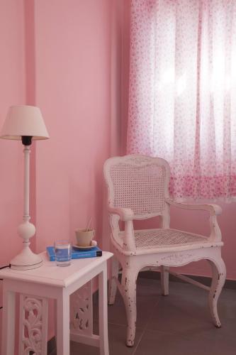 a room with a chair and a table with a lamp at Senses Boutique Hotel in Imerovigli