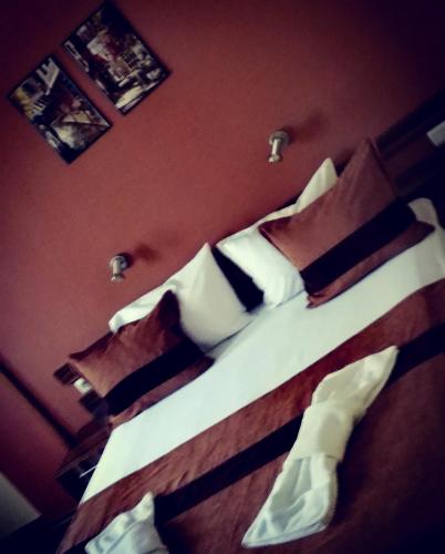 a bedroom with two beds with white sheets and pillows at Hotel Mizia in Targovishte