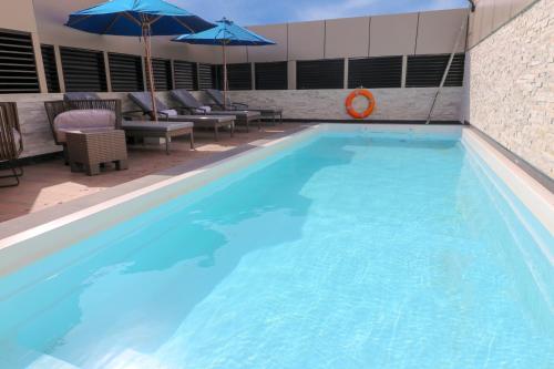 فندق فرنتيل جدة التحلية في جدة: حمام سباحة أزرق كبير مع الكراسي والمظلات