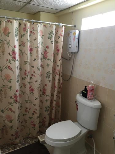 a bathroom with a toilet and a shower curtain at Baan Khun ya Ayutthaya in Phra Nakhon Si Ayutthaya