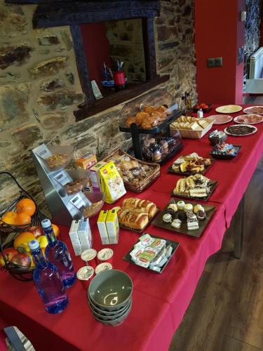 a table with a red table cloth with food on it at Hotel Rural Pescadores in Sobrado
