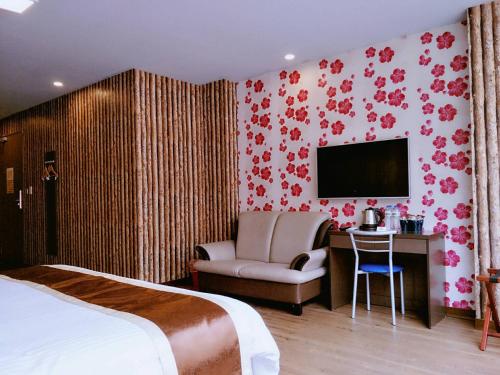 ein Hotelzimmer mit einem Bett, einem Stuhl und einem TV in der Unterkunft A Ace Hotel in Taichung