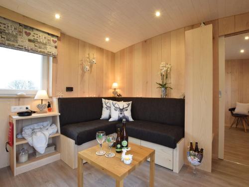 un soggiorno con divano e tavolo di Quaint Mobile Home with Sauna in Vielsalm a Vielsalm