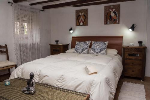 Un dormitorio con una cama grande con un libro. en L'Arc de Pedra, en Vilafamés