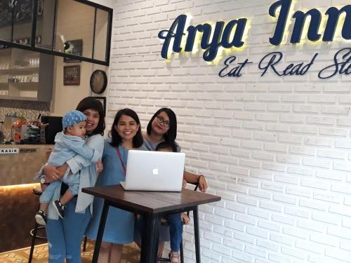 a group of women standing around a table with a laptop at Arya Inn in Pematangsiantar