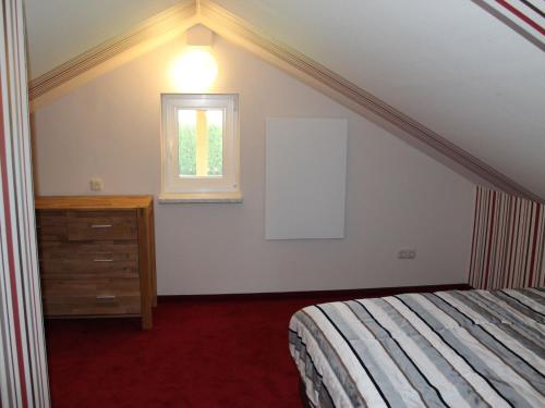 ein Schlafzimmer mit einem Bett, einer Kommode und einem Fenster in der Unterkunft Sunlit Holiday Home with Fenced Garden in Bastorf in Bastorf