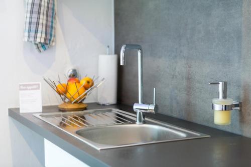 a kitchen counter with a sink and a bowl of fruit at Altstadt Apartments in Kirchheim unter Teck