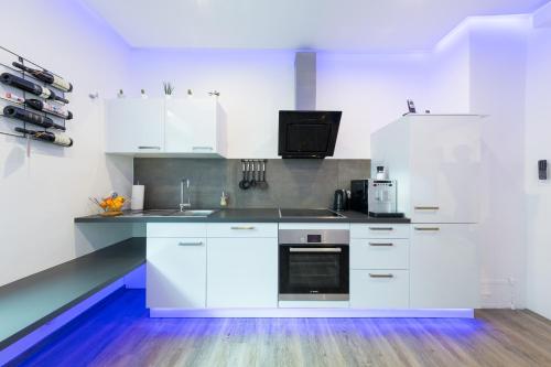 a white kitchen with white cabinets and a sink at Altstadt Apartments in Kirchheim unter Teck