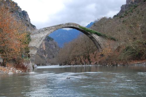 an old stone bridge over a river in a canyon at Hotel Faraggi in Kleidonia