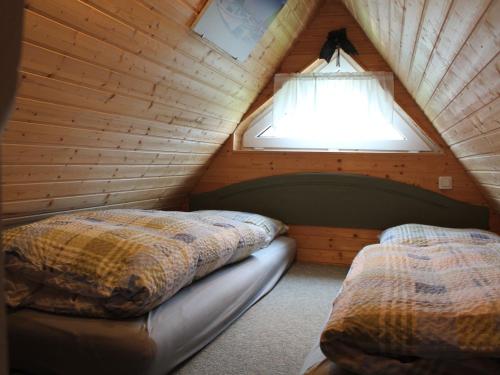 a bedroom with two beds in a wooden attic at Quaint Holiday Home in Schwaan near the Lake in Schwaan