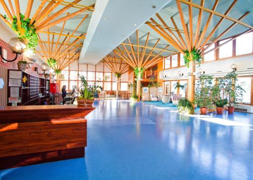 a large lobby with blue floors and potted plants at Hotel Panorama in Szczecin