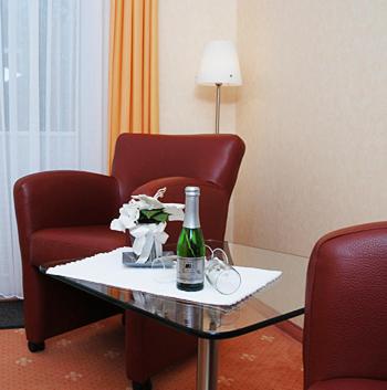 a room with a table with a bottle of wine and a chair at Aqua Marina in Helgoland