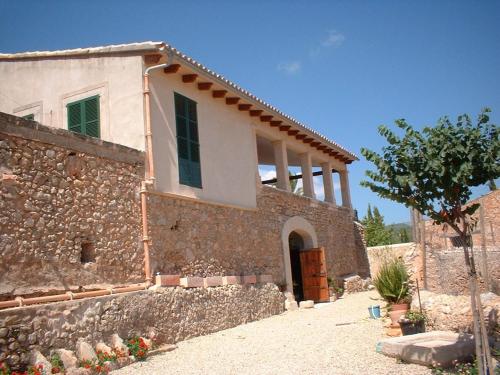 una casa con una pared de piedra y un edificio en Belvilla by OYO Villa 13, en Consell