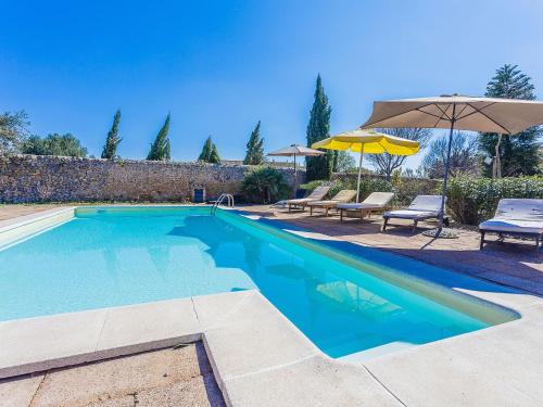 una piscina con 2 sillas y una sombrilla en Belvilla by OYO Villa 13, en Consell