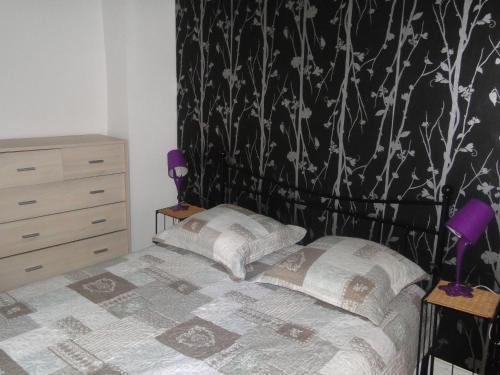 - une chambre avec un lit et du papier peint noir et blanc dans l'établissement Appartement NOTRE DAME, à Paris