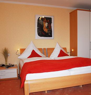 a bedroom with a bed with red and white pillows at Aqua Marina in Helgoland