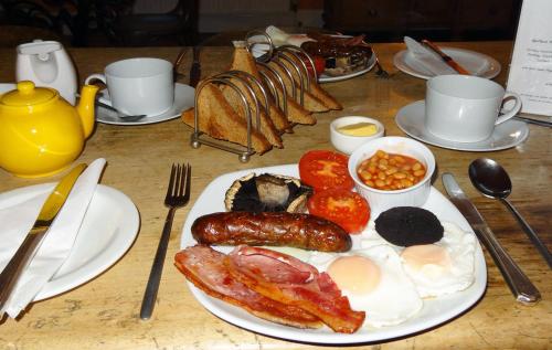 a table with a plate of food with sausage and beans at Spillers Farm in Axminster
