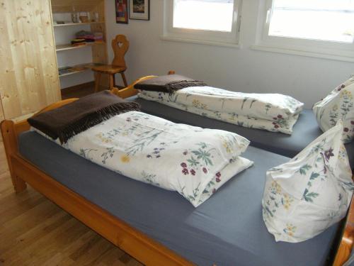 2 camas con almohadas en una habitación en BnB Niederer en La Côte-aux-Fées