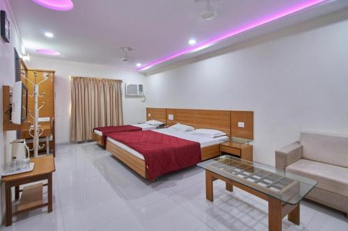 a hotel room with a bed and a couch at Hotel Sarita in Surat