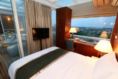a bedroom with a bed and a desk and a window at Aleex Villa in Yuanshan