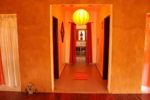 a hallway with orange walls and a chandelier at Le Lodge Dalaal Diam in Somone