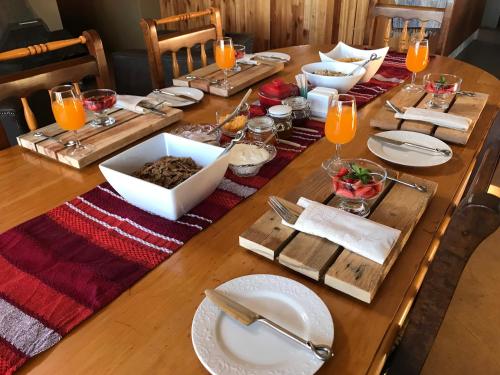 a long wooden table with plates and bowls of food at White Linen Guesthouse in Tierpoort