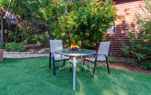 two chairs and a table with a bowl of fruit on it at Mazal shell Zimmer in Amirim