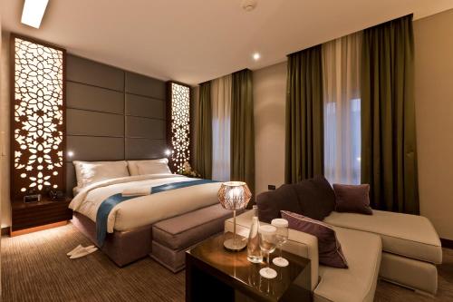 a hotel room with a bed and a couch at Zubarah Hotel in Doha