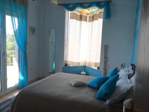 ein blaues Schlafzimmer mit einem großen Bett mit blauen Kissen in der Unterkunft Vegoritida Apartments in Edessa