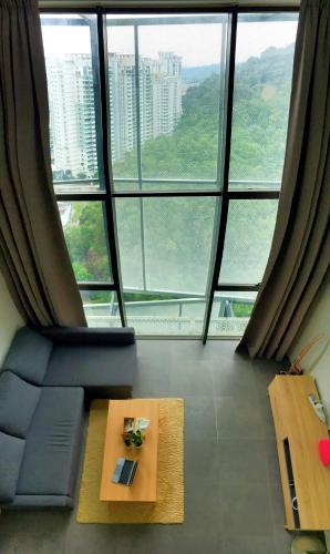 a room with a couch and a table in front of a large window at 2Stories Empire Duplex at Damansara Perdana in Damansara Perdana