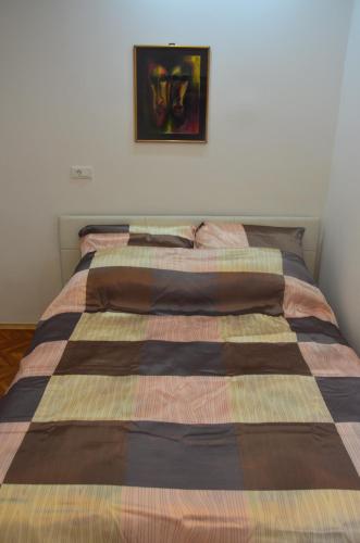 a bed in a bedroom with a picture on the wall at Sarajevo City Center in Sarajevo