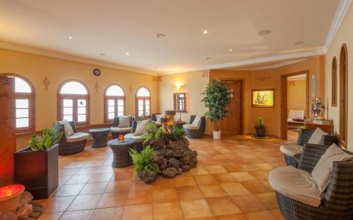 a large living room with couches and chairs at Hotel Am Eifelsteig in Neroth