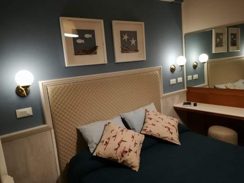リド・ディ・カマイオーレにあるHotel Ristorante La Terrazzaのベッドルーム(シンクと鏡付きのベッド付)