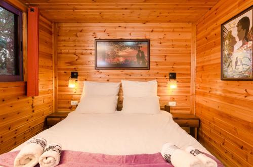 a bedroom with a bed in a log cabin at Mazal shell Zimmer in Amirim