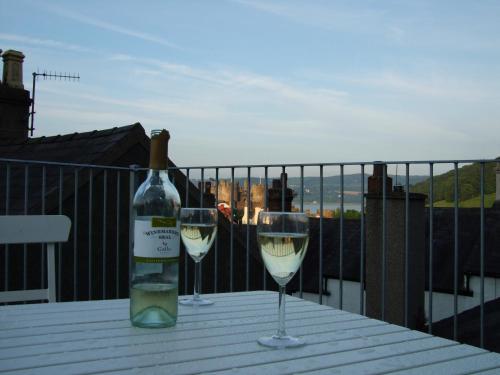 a bottle of wine and two glasses on a table at Conwy View Cottage in Conwy