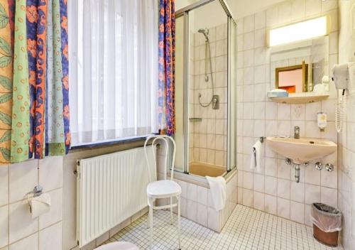 a bathroom with a sink and a shower at Hotel am Friedensplatz in Stuttgart