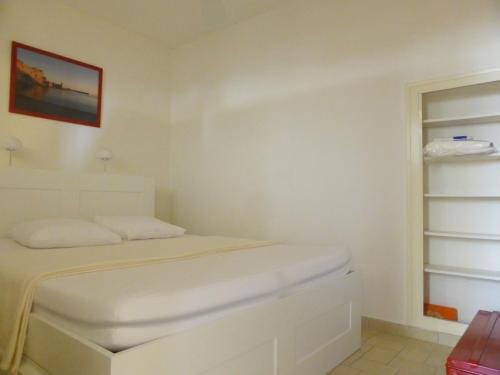 une chambre blanche avec un lit et un placard dans l'établissement 2EGA41 Studio Intra-muros proche plage, à Collioure